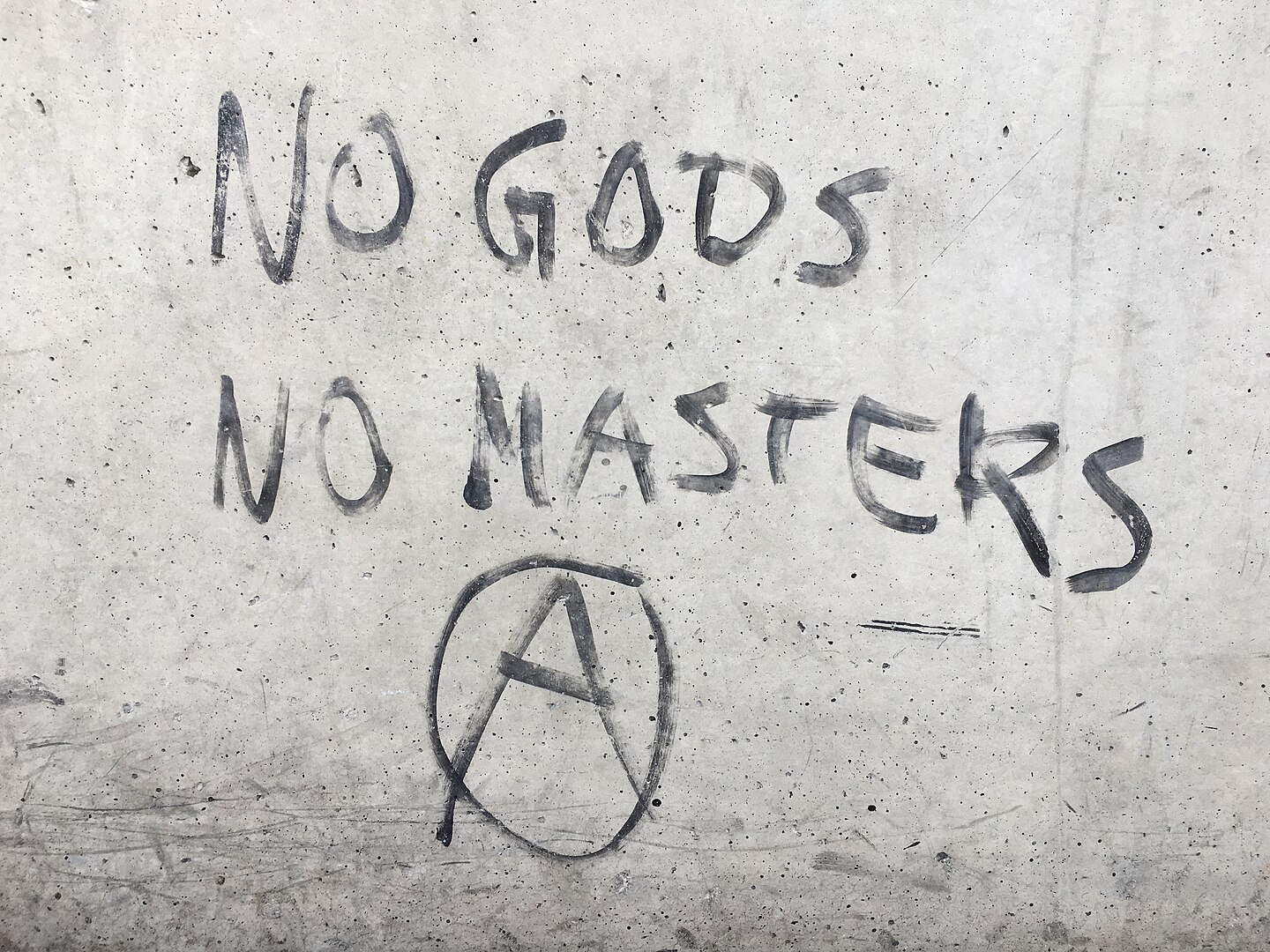 Graffiti with the slogan "no gods, no masters" and the anarchist "A" symbol on a concrete wall in the central bus station of Munich, Germany, in 2022 Graffiti with the slogan "no gods, no masters" and the anarchist "A" symbol on a concrete wall in the central bus station of Munich, Germany, in 2022